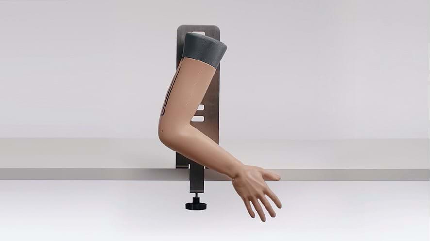 Colles' Fracture Reduction Trainer in light skin tone attached to table using stand 