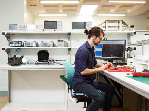 Our Lead Systems & Software Engineer works on a circuit board